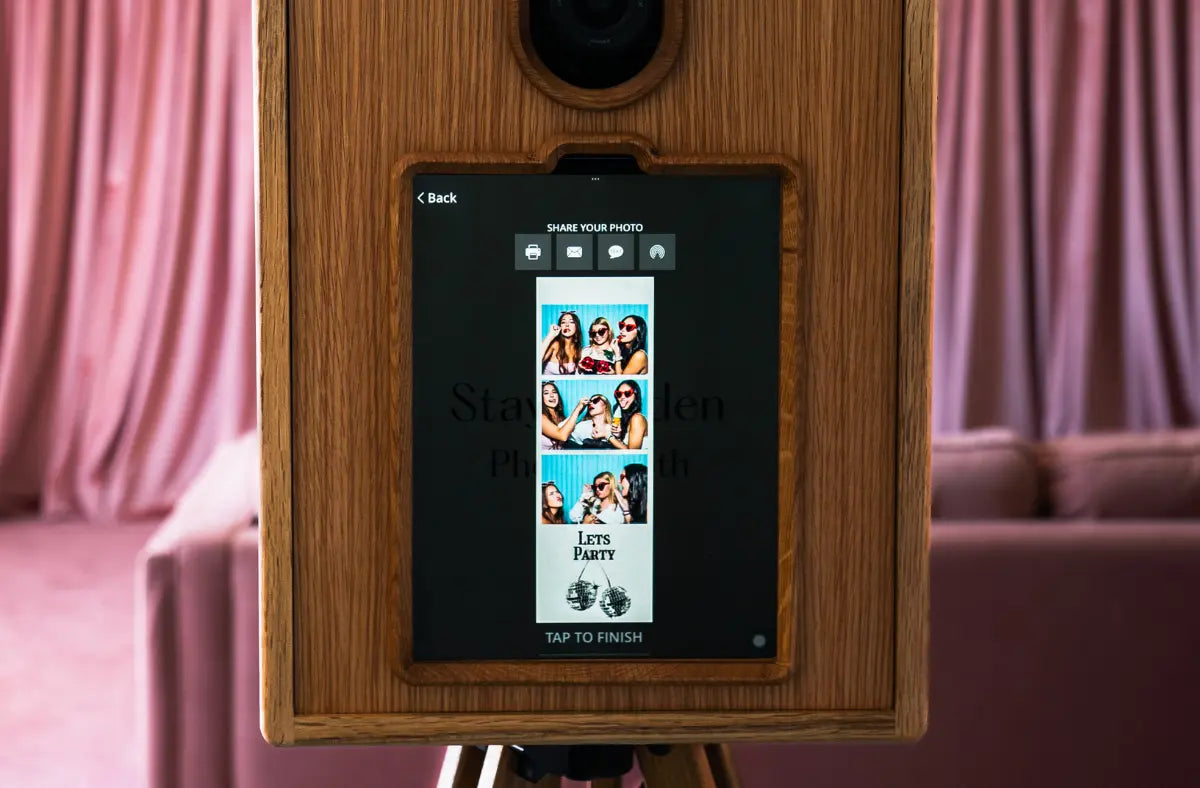 Wooden Glamour Booth touchscreen displaying a guest photo strip with sharing options at an event.